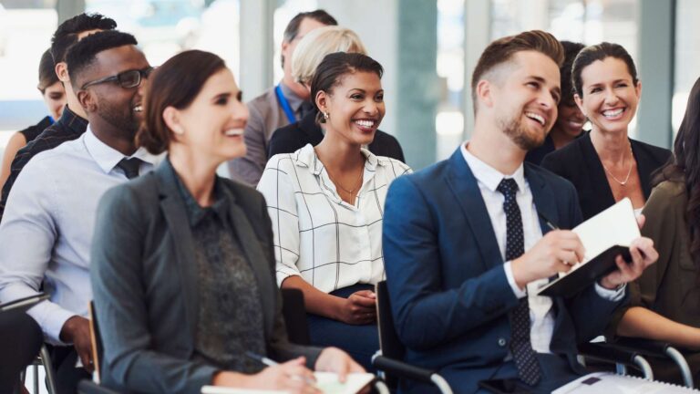 Diverse group smiling in professional seminar