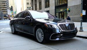 Luxury black sedan parked on city street.